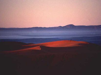 Amanecer en las dunas de Merzouga, al sur de Marruecos; al fondo, la cordillera del Atlas.