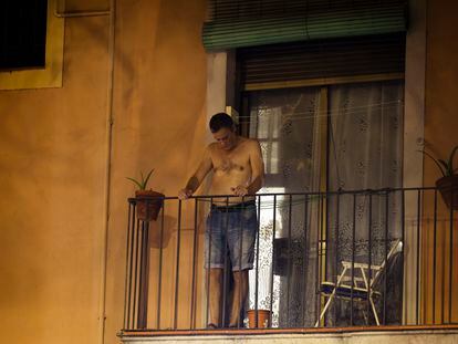 Un vecino del Raval, el lunes por la noche con el termómetro rozando los 31 grados, en el balcón de su casa.