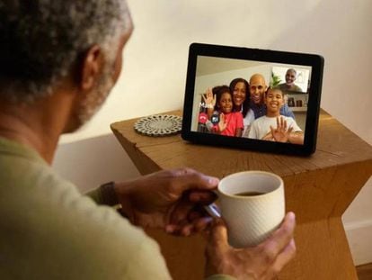 Un hombre se comunica por remoto con su familia, que aparece en la pantalla de la tableta.