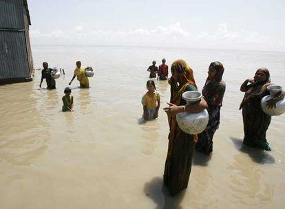 Mujeres y niños en el río Jamuna, en Bangladesh, desbordado tras las lluvias.