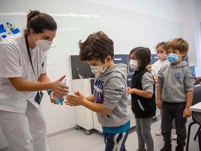 La enfermera del colegio Aldapeta María, en San Sebastián, ofrece gel hidroalcohólico a alumnos del centro antes de comenzar la clase.