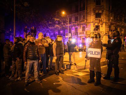 El diputado ultra, a la derecha con los brazos cruzados, frente a varios antidisturbios, anoche en la calle de Ferraz de Madrid.