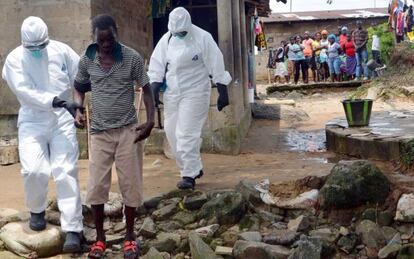 Personal médico escolta a un enfermo en Monrovia, Liberia.