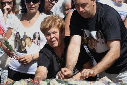 Familiares depositan flores en las placas que recuerdan en Barajas a los fallecidos.