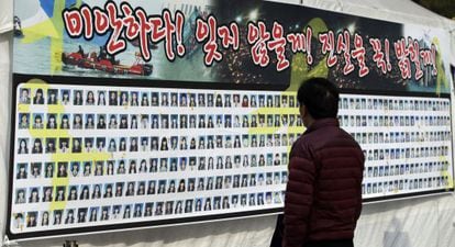 Un hombre observa un cartel con las caras de las víctimas del Sewol.