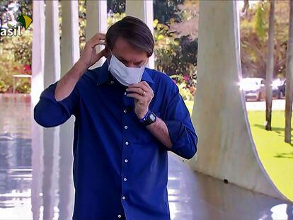 El presidente Jair Bolsonaro se coloca la mascarilla este martes para hablar en ante los medios de comunicación.