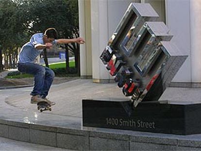 Un joven pasa con su monopatín ante el logotipo de Enron, en la sede de la compañía en Houston.
