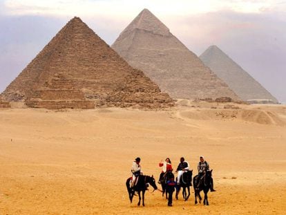 Turistas frente a las tres pirámides de Guiza.