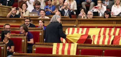 La diputada de Catalu&ntilde;a si que es pot, Angels Mart&iacute;nez retira las banderas de Espa&ntilde;a de los esca&ntilde;os del PPC.