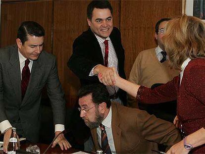 Concha Caballero (IU) saluda a Carlos Rojas (PP) por encima de la cabeza de Manuel Gracia (PSOE).