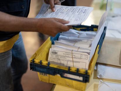 Un cartero entrega los votos por correo en una mesa electoral en Barcelona, este domingo.