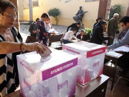 Una ciudadana deposita su voto en una mesa electoral en Michoac&aacute;n.