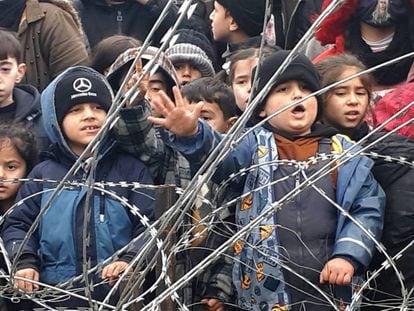 Niños migrantes se reúnen cerca de la valla en la frontera entre Polonia y Bielorrusia, cerca de Kuznica (Polonia), este jueves.