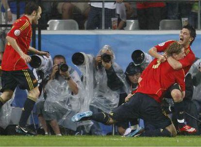 Villa abraza a Fernando Torres mientras Iniesta corre hacia ellos en la celebración del primer gol de España.
