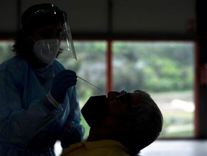 Una trabajadora sanitaria realiza una prueba PCR a un hombre durante el cribado realizado este lunes a la población de Sobradelo (Galicia).