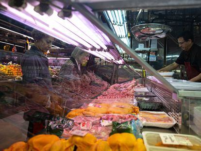 Dos mujeres compran en una carnicería en un mercado de Madrid.