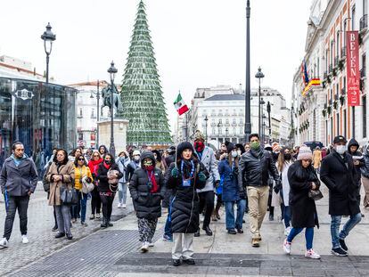 Un grupo de turistas pasean por la Puerta del Sol de Madrid, este diciembre.