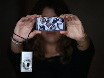 Una persona haciendo fotos con el m&oacute;vil en lugar de usar la c&aacute;mara compacta. 