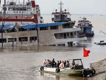 Trabajadores sobre el barco naufragado tras lograr enderezarlo.