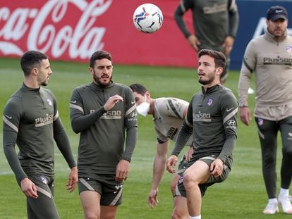 Mario Hermoso, Koke y Sául, dan toques a un balón bajo la atenta mirada de Simeone durante el último entrenamiento del Atlético previo al partido de este domingo ante el Sevilla en el Sánchez Pizjuán. / Chema Moya (EFE)