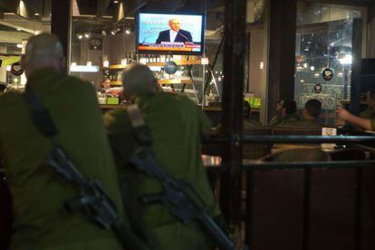 Soldados israelíes miran por televisión un discurso de Benjamin Netanyahu después del alto el fuego.