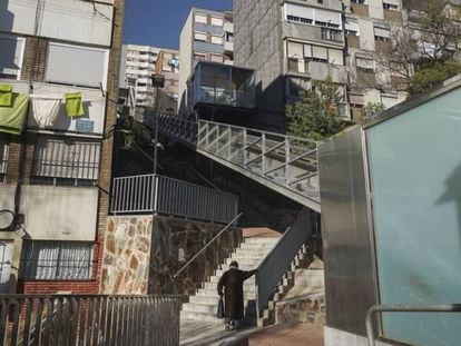 Una mujer subre las escaleras del barrio de Ciutat Meridiana, en Barcelona.