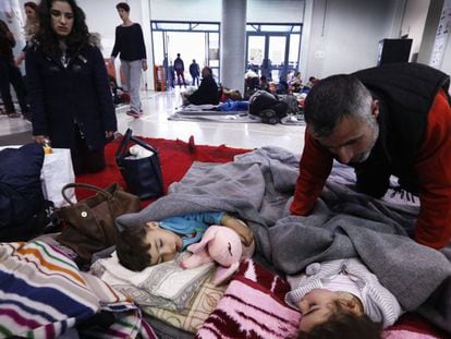Unos migrantes descansan este martes en un edificio del puerto de El Pireo.