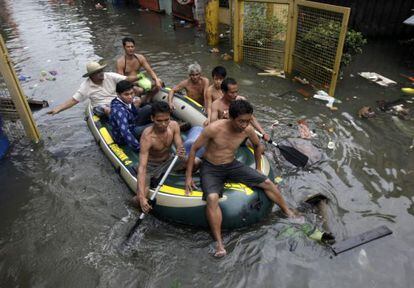 Ciudadanos filipinos afectados por las inundaciones se trasladan en una balsa hinchable en lQuezon, al este de Manila.