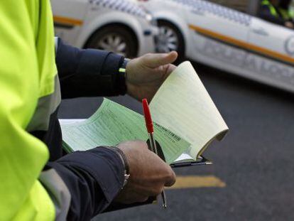 Un agente de la Policía Local de Sevilla rellena el papeleo de una multa.