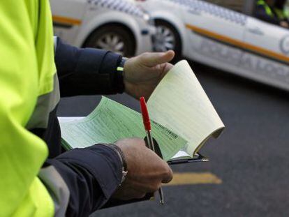 Un agente de la Polic&iacute;a Local de Sevilla rellena el papeleo de una multa.