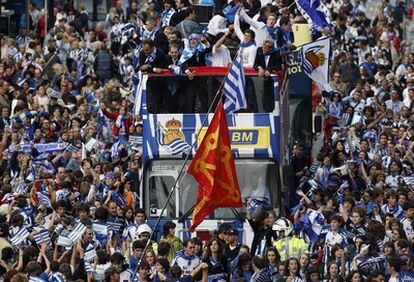 Los aficionados celebran alrededor del autobús del los jugadores el ascenso.