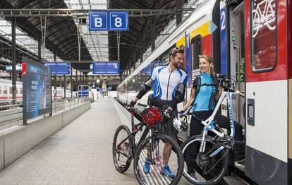 Dos ciclistas suben a un tren de SBB, la red de ferrocarriles de Suiza, uno de los paraísos del cicloturismo.