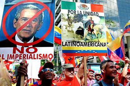 Seguidores de Chávez portan carteles contra Bush y a favor de la unidad regional en la marcha del sábado en Caracas.