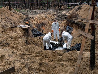 Un grupo de expertos exhuma un cadáver de una fosa común hallada en la ciudad oriental de Izium, recuperada por el ejército ucranio esta semana.