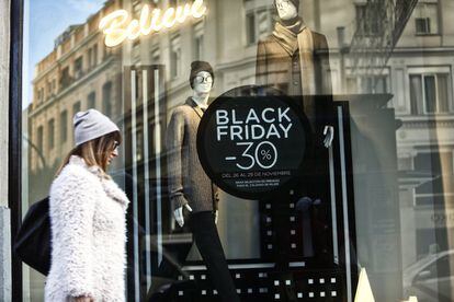 El 'Black Friday', que desembarcó en España hace un par de años y se ha consolidado en el mercado nacional. En la imagen, una mujer pasa junto a una tienda que ofrece grandes descuentos en Madrid.