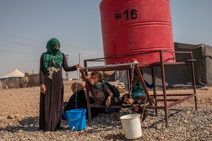 Una mujer de Homs desplazada en el campamento de Al Alsadya, cerca de la ciudad de Raqa, llena un cubo en el tanque del campamento, la única fuente de agua disponible.