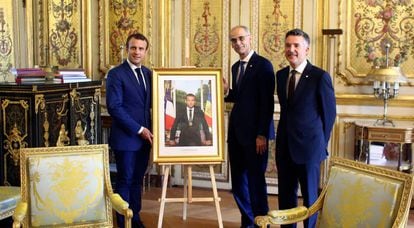 Emmanuel Macron, co-príncipe de Andorra, muestra su retrato oficial con la bandera andorrana junto a los jefes del ejecutivo y el legislativo, Antoni Martí y Vicenç Mateu