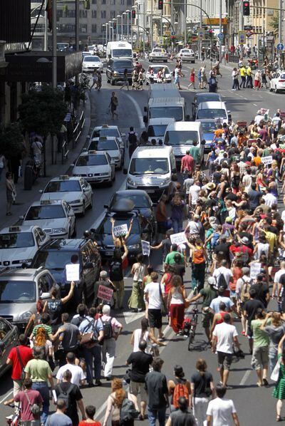 Decenas de simpatizantes del Movimiento 15-M marchan por la Gran Vía de Madrid tras impedirles la policía el acceso a Sol.