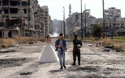 VIDA MÁS ALLÁ DE LA GUERRA. Dos recién casados sirios, Nada Merhi, de 18 años, y el soldado del régimen Hassan Youssef, de 27, posan el viernes para sus fotos de boda en mitad de la destrucción de Homs. El fotógrafo dice que quiere reflejar que la vida es más fuerte que la muerte.