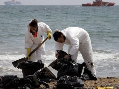 Operarios de limpieza del Ayuntramiento de Valencia recogen &quot;galletas&quot; de chapapote producidas por un vertido de fuel en la playa de El Saler, en abril de 2014. EFE/  