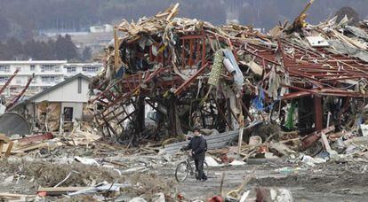 Un hombre camina sobre un pueblo destrozado por el terremoto y el tsunami en la prefectura de Iwate