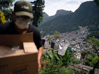 Un voluntario carga una caja de jabón y detergente en Río de Janeiro, el pasado martes.