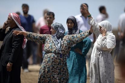Varias kurdas esperan a sus parientes huidos de Kobane en la frontera. 