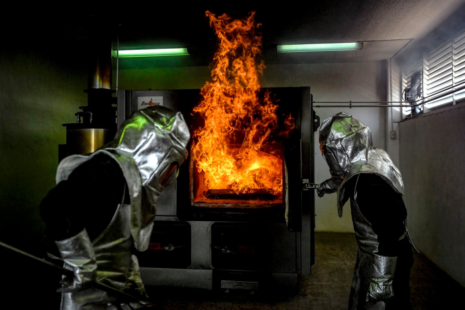 Juan Cruz y Victor Cruz preparan el horno crematorio del Panteón Municipal de Nezahualcóyotl en mayo de 2020; durante el primer pico de la pandemia en el Valle de México.