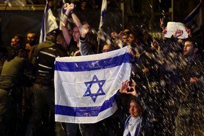 Varios manifestantes sujetan la bandera nacional de Israel durante las protestas en Jerusalén, este domingo.  