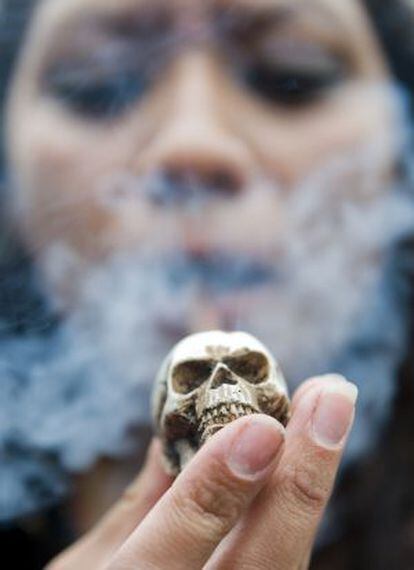 Una mujer fuma en pipa en una manifestaci&oacute;n por la legalizaci&oacute;n de la marihuana en M&eacute;xico.