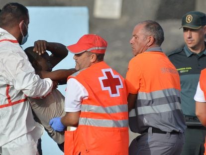 Los servicios de emergencia atienden a una de las 316 personas que han llegado este domingo a bordo de dos cayucos al puerto de La Restinga, en El Hierro, rescatados por Salvamento Marítimo.