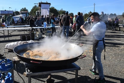 Un agricultor prepara la comida en una paellera gigante, mientras los tractores bloquean la autopista AP-7 a la altura de Pontós, este miércoles.