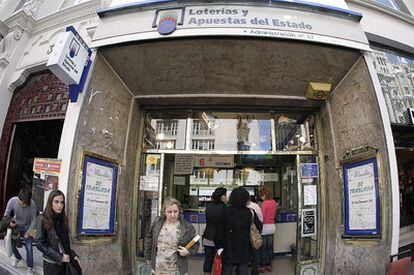 Entrada a la administración de lotería con los carteles que anuncian el traslado.