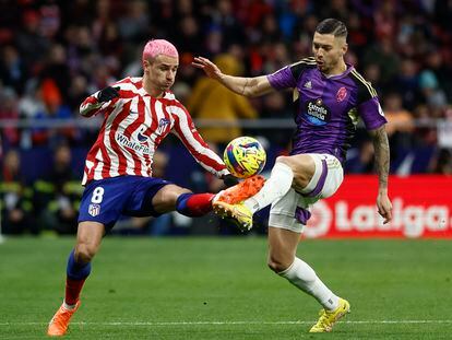 Antoine Griezmann en una acción con Javier Sánchez durante el partido de la Liga entre el Atlético de Madrid y el Valladolid, en el Metropolitano este sábado.